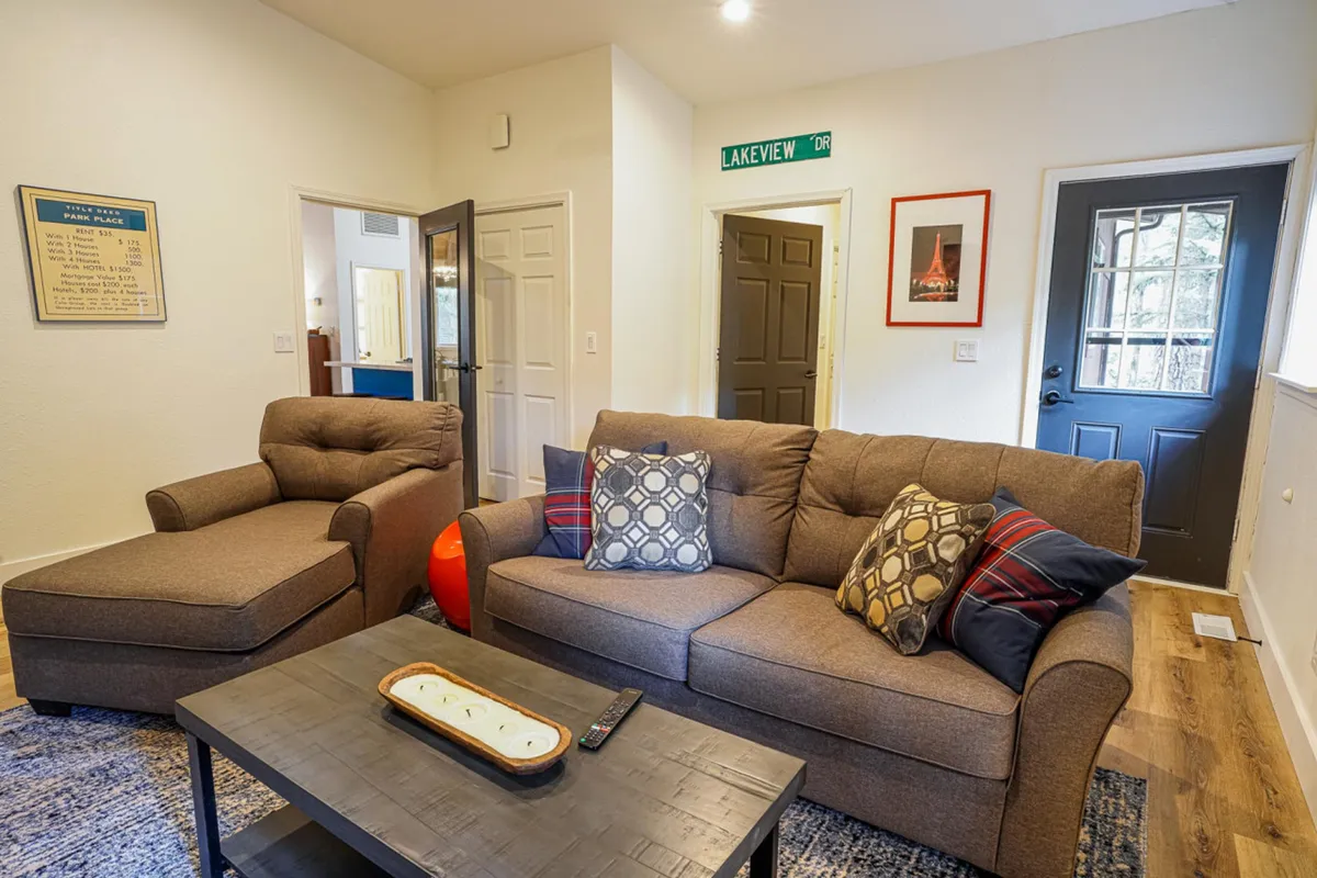 A cozy living area with a plush sofa, coffee table, and armchair, this space invites relaxation and intimate gatherings. The arrangement is conducive to playing board games, engaging in conversation, or simply enjoying a tranquil moment, embodying the cozy and intimate side of the cabin's dual living spaces.